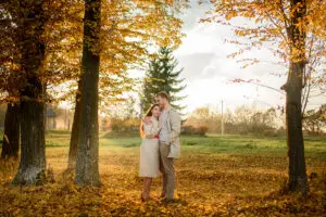 Young couple in love holding hands and walking through a park on a sunny autumn day
