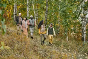 Group of people walking through a wooded area.